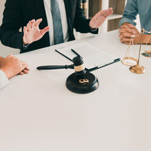 Lawyer advising clients on filing for divorce, with a gavel and legal documents on the table